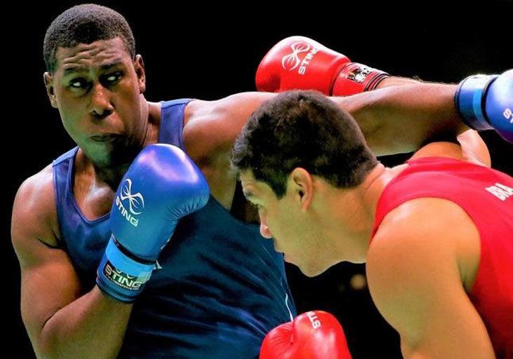 COMPLYING WITH PANDEMIC RESTRICTIONS: Trinidad and Tobago super-heavyweight Nigel Paul, left, seen in action, is awaiting word of a new date for Olympic qualifying for the Americas.