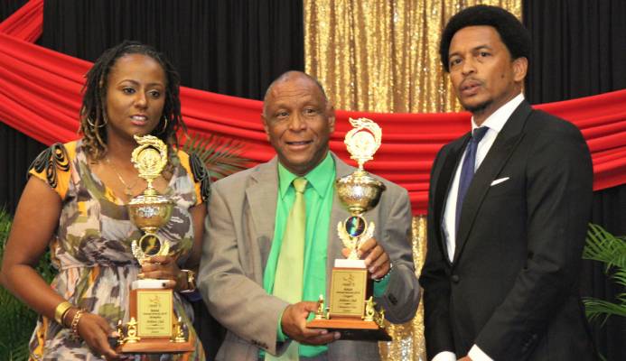 "Memphis Pioneers’ Antonia Burton, left, and Cougars Athletics’ Kelvin Nancoo, centre, with Trinidad and Tobago Olympic Committee president Brian Lewis after receiving the joint Champion Junior Club award on behalf of their clubs at the NAAA’s 2019 Awards Function at the Radisson Hotel, Port-of-Spain, on Saturday evening. "