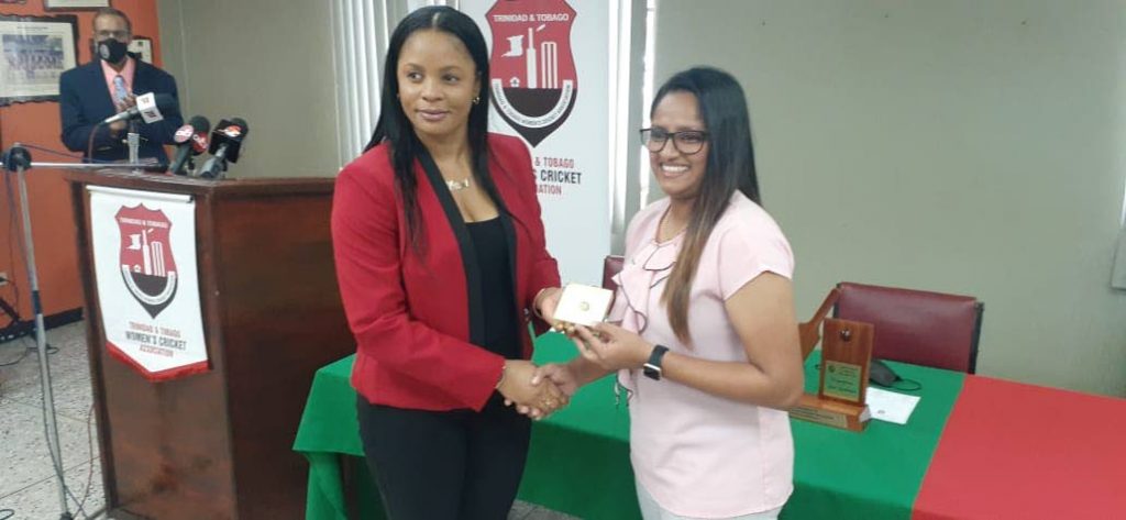 Merissa Aguilliera , left, presents Anisa Mohammed with a ring inscribed with Mohammed's initials and her playing kit number on behalf of the TT Women's Cricket Association, at theNational Cricket Centre, Couva, on Monday. - Photo courtesy TTWCA