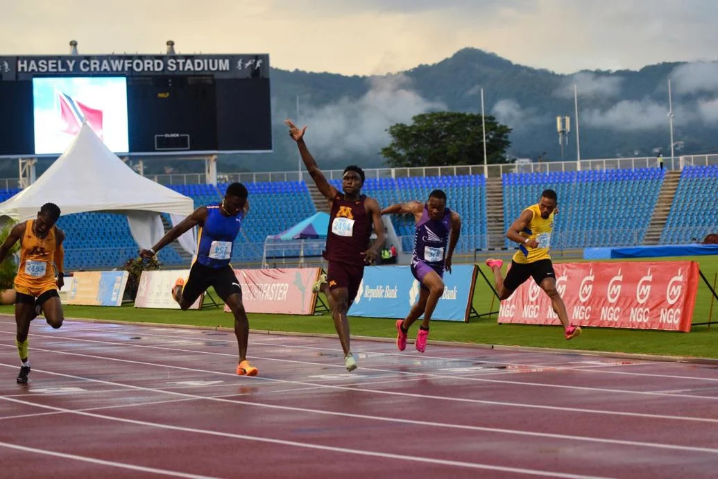 SPRINT CHAMPION: Devin Augustine, centre, wins the men’s 100 metres final on day one of the NGC NAAATT National Open Championships at the Hasely Crawford Stadium, in Port of Spain, yesterday. Augustine stopped the clock at 10.26 seconds. Jerod Elcock, second from left, finished second in 10.27. Revell Webster, not in photo, secured the third spot in 10.36. Kion Benjamin, left, was sixth in 10.42, while Omari Lewis, second from right, and Judah Taylor, right, were fourth and fifth, respectively, clocking 10.37 and 10.41. —Photo: JERMAINE CRUICKSHANK (Image obtained at trinidadexpress.com)